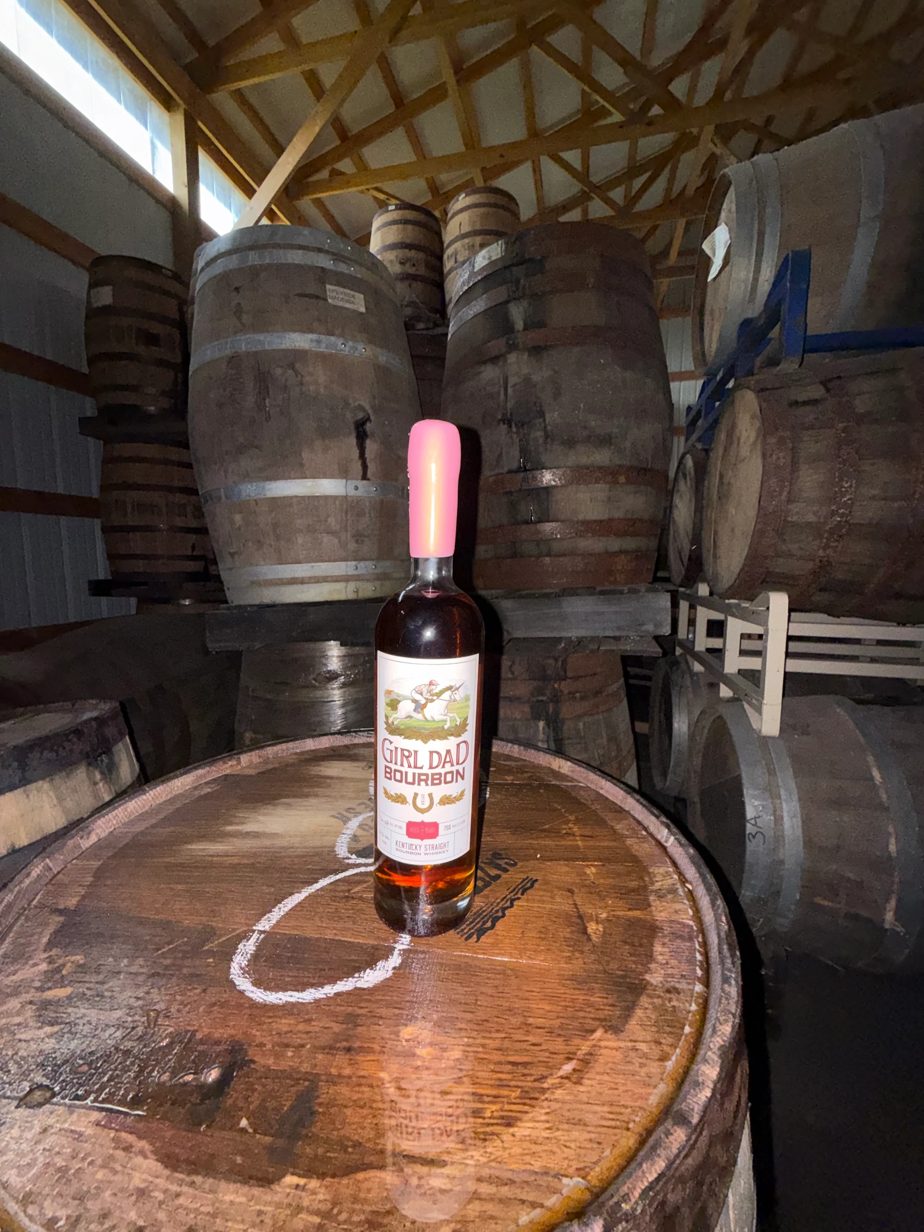 Girl Dad Bourbon Founders Batch bottle on barrel in the barrel room